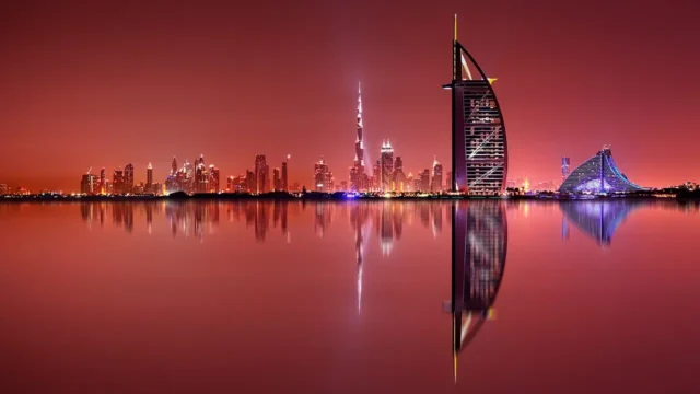 夕焼けの空と水面に映るUAEの都市景観